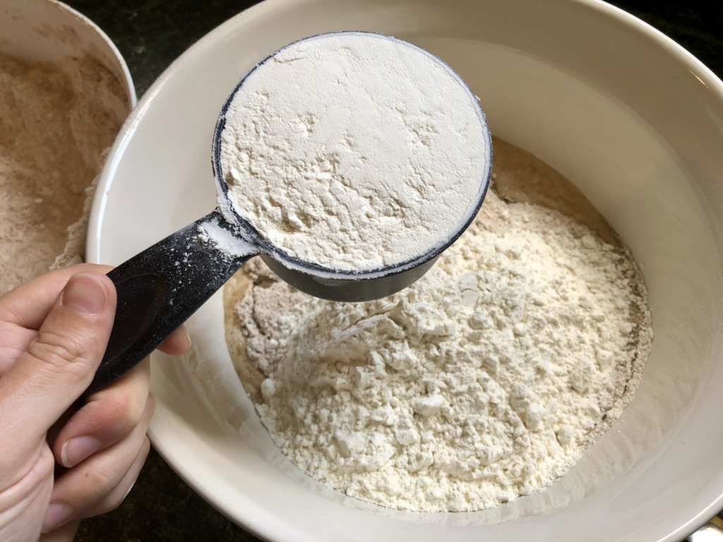 adding flour to pizza dough