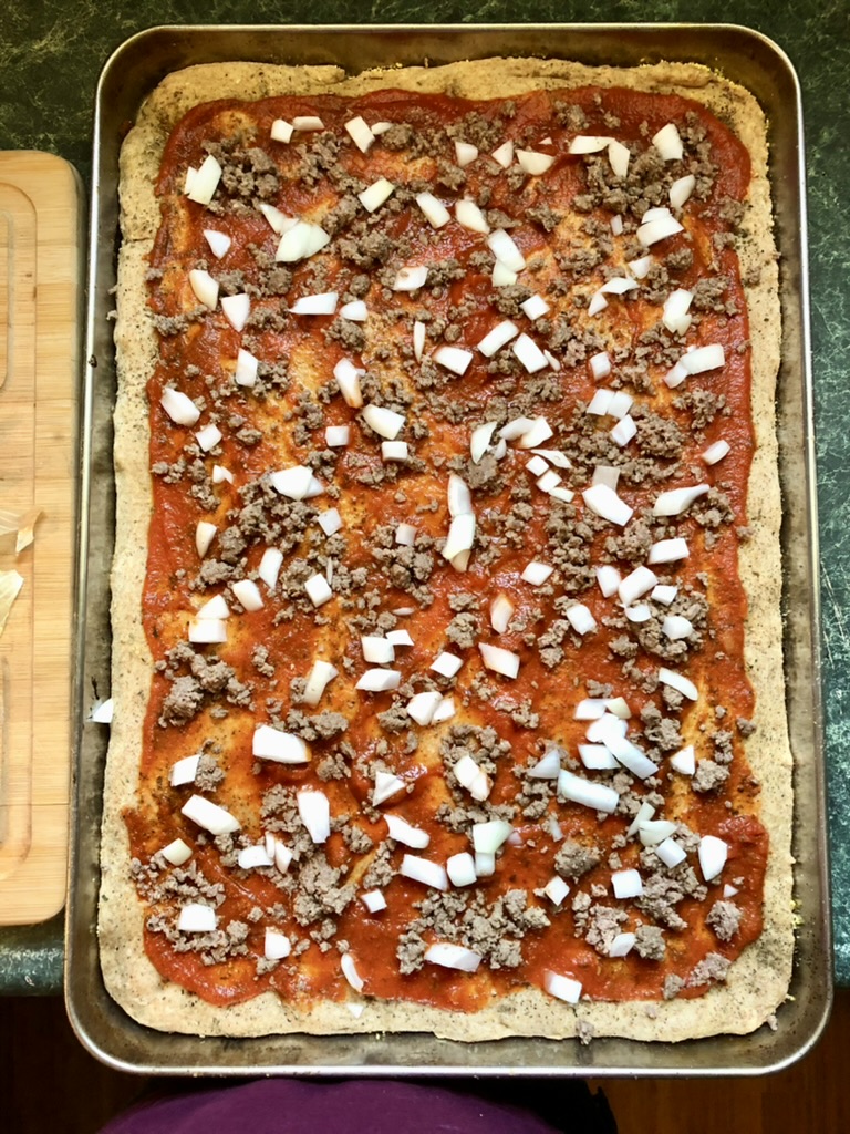 pizza dough with meat and vegetable toppings