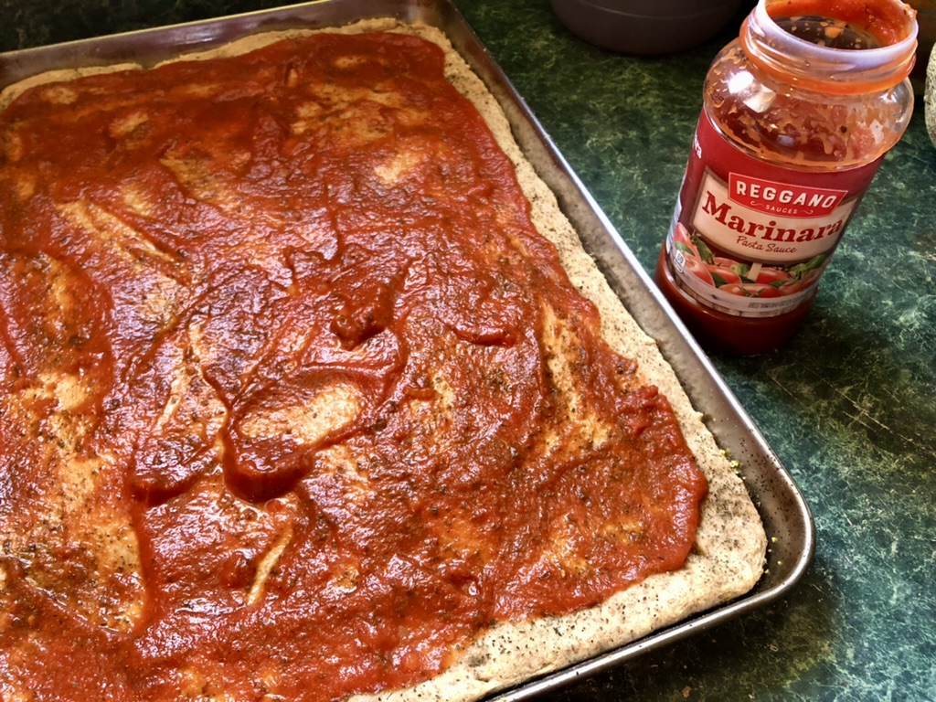 pizza dough with sauce added