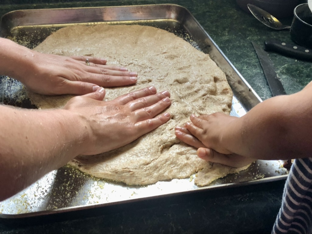 spreading out pizza dough